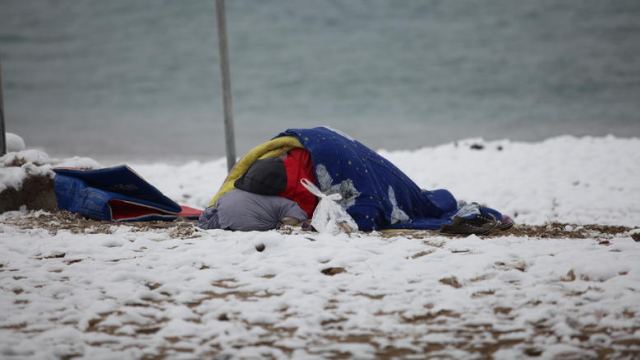 Συγκλονιστική φωτογραφία αστέγου που κοιμάται σε χιονισμένη παραλία