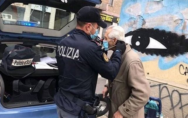 Viral η συγκινητική φωτογραφία με Ιταλούς αστυνομικούς που φορούν μάσκα σε ηλικιωμένο