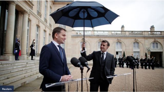 Η γαλλική ευγένεια του Μακρόν - Κρατούσε την ομπρέλα για να μη βραχεί ο Σλοβάκος πρωθυπουργός [Εικόνες-βίντεο]