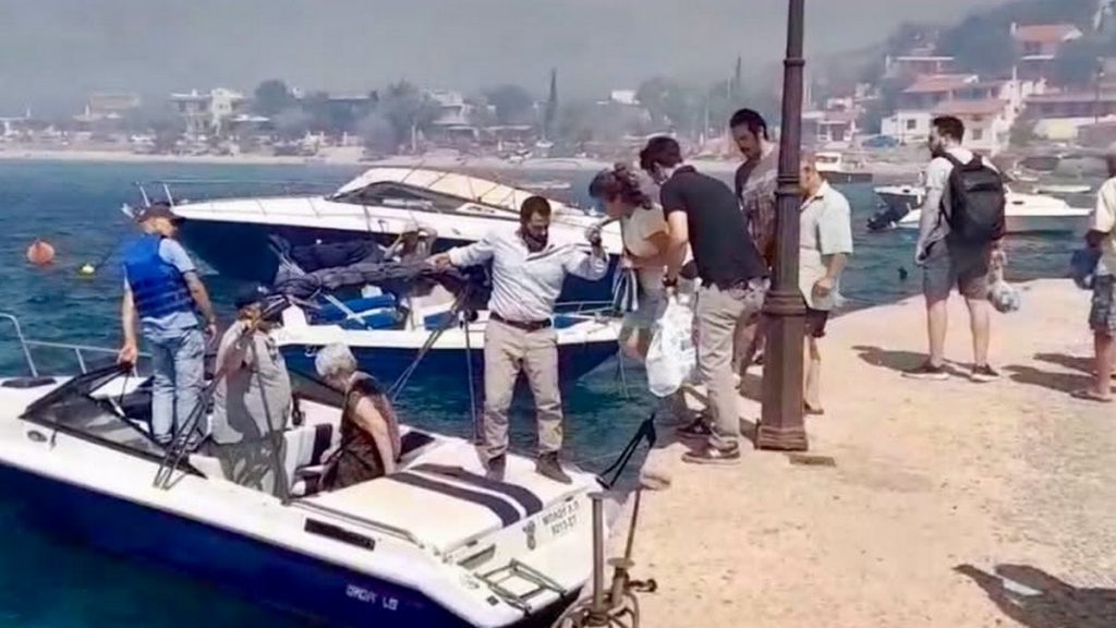 Ο Φάνης Σπανός πάνω στη βάρκα βοηθάει στην απομάκρυνση των κατοίκων στην πυρκαγιά της Βοιωτίας - Δείτε εικόνες